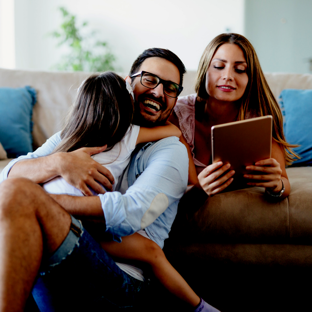 Picture of family on couch enrolling in activities from a tablet